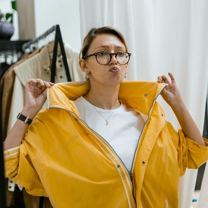femme qui essaie un vêtement mal taillé inconfortable dans une boutique de prêt-à-porter