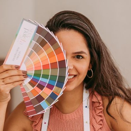 femme qui positionne un nuancier de couleurs directement devant la moitié de son visage